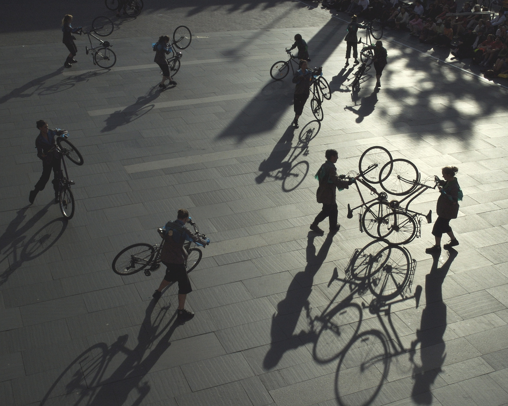 silhouettes of participants lifting bikes on back wheels