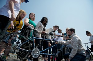 VIPs & performers crowd around a tandem to explore the bike during a Touch Tour before an Everyday Hero performance 2013 © Ray Gibson