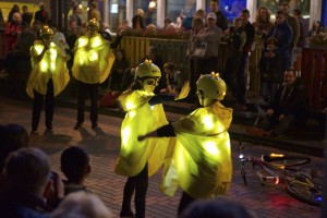 Yellow glowing performing miming being on a bike is halted by the hand from another held in front of their face